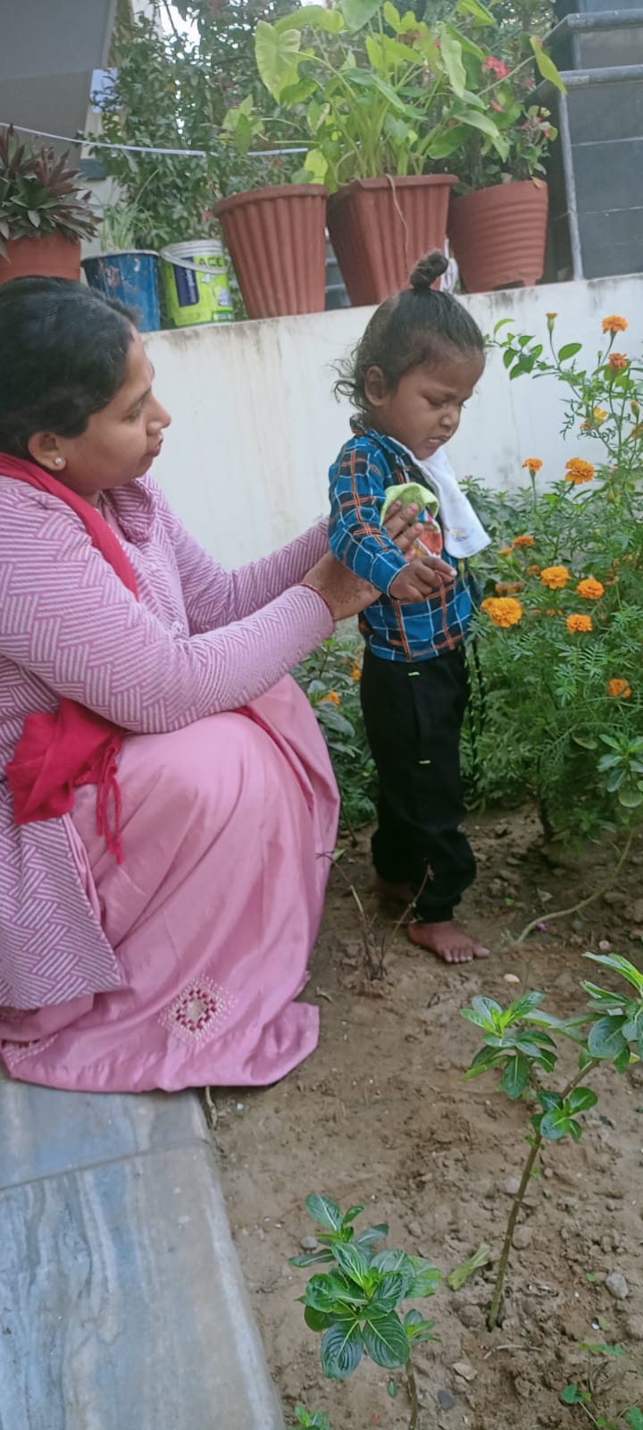 A child planting seedlings with a volunteer